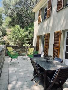 een patio met een tafel en stoelen en een gebouw bij Villas A Torra in Patrimonio