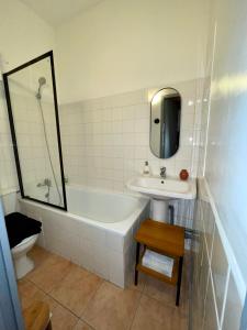 uma casa de banho com uma banheira, um lavatório e um espelho. em Cocon au cœur du centre-ville d'Arles em Arles