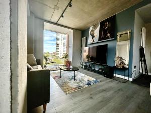 sala de estar con sofá y TV en Captivating 2-Bed Skyview Apartment in Leeds, en Leeds