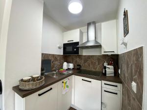 a small kitchen with white cabinets and a sink at Alpenchic in Oberstaufen