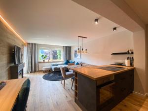 Bergidyll في اوبرستوفن: مطبخ وغرفة معيشة مع طاولة وأريكة