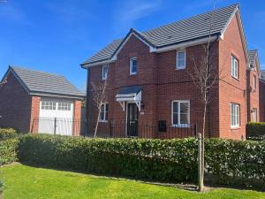 a brick house with a fence in a yard at Remarkable 3-Bed House in Wirral in Wirral