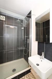 La salle de bains est pourvue d'un lavabo et d'une douche. dans l'établissement W London apt for 4. Open plan kitchen/living room, à Londres