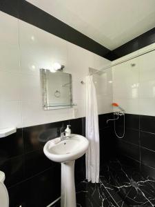a black and white bathroom with a sink and a mirror at Piligrim Kazbegi in Kazbegi +29 photos