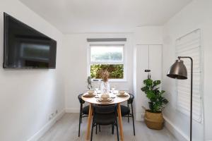 W London apt for 4. Open plan kitchen/living room في لندن: غرفة طعام مع طاولة ونافذة