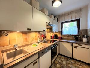 a kitchen with white cabinets and a sink at Ferienwohnung Schwanennest in Füssen