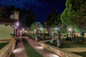 Holiday Home Giardino Marino في بومير: حديقة في الليل مع أضواء
