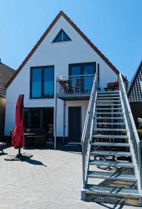 una casa blanca con una escalera delante en Norderbarg, en Bredstedt