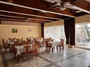 a dining room with tables and chairs and a ceiling fan at Хотел Диамант Hotel Diamond in Balchik