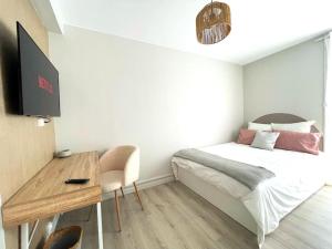 niewielka sypialnia z łóżkiem i biurkiem w obiekcie Le Compans: exceptionnel T5 en berges du Canal w Tuluzie