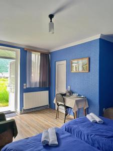 a room with two beds and a table in it at Piligrim Kazbegi in Kazbegi