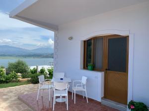 a patio with a table and chairs and a view of the water at Villas Ermali in Ksamil
