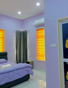 a bedroom with purple bed and orange blinds at Aisyy homestay in Kampong Sungai Baru