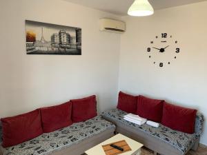 a living room with a couch and a clock on the wall at Villas Ermali in Ksamil