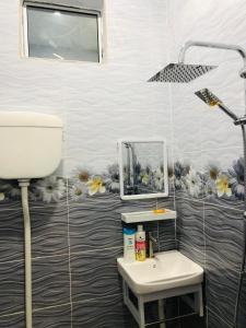 un bagno con un lavandino e un acquario sul muro di Aisyy homestay a Kampong Sungai Baru
