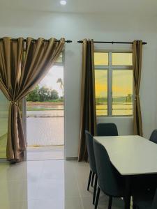 una sala da pranzo con tavolo e finestra di Aisyy homestay a Kampong Sungai Baru