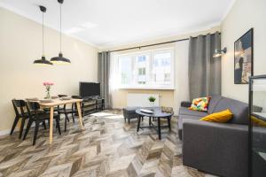 a living room with a couch and a table at Apartament 109 w centrum Gdyni ProstyWynajem in Gdynia