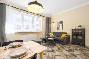 a living room with a couch and a table at Apartament 109 w centrum Gdyni ProstyWynajem in Gdynia