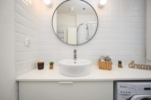 a white bathroom with a sink and a mirror at Apartament 109 w centrum Gdyni ProstyWynajem in Gdynia +32 photos