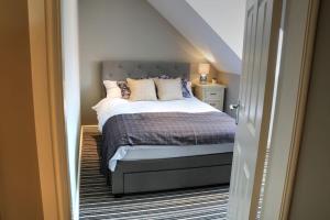 Un dormitorio con una cama con almohadas. en Luxury Holiday Cottage. Beverley. Parking, en Beverley