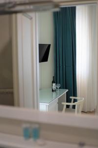 um quarto com uma mesa e uma cortina verde em Crown Hotel em Kutaisi
