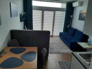 uma sala de estar com um sofá azul e uma mesa em Aparta Lotnisko em Breslávia
