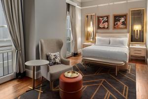 um quarto de hotel com uma cama e uma cadeira em The Tremont House, Galveston, a Tribute Portfolio Hotel em Galveston