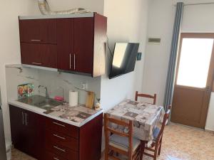a kitchen with a sink and a table with chairs at Villas Ermali in Ksamil