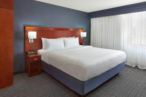 a bedroom with a large bed and a blue wall at Courtyard by Marriott Waterloo St. Jacobs in Waterloo