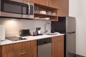 a kitchen with a stainless steel refrigerator and a sink at Courtyard by Marriott Waterloo St. Jacobs in Waterloo
