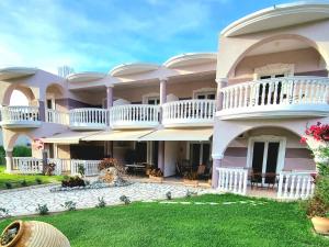 a large building with balconies and a yard at Marathon Studios & Apartments in Keri