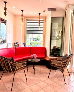 een woonkamer met een rode bank en stoelen bij Hotel Amelia in Fano