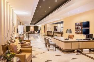 a lobby with a reception desk and chairs at Sheraton Chihuahua Soberano in Chihuahua