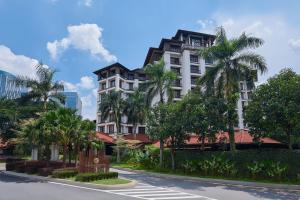 a building with palm trees in front of a street at Palm Garden Hotel, Putrajaya, a Tribute Portfolio Hotel in Putrajaya