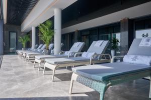 a row of chaise lounge chairs on a patio at WHITE HILLS HOTEL spa&sport in Uzhhorod