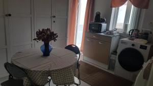 a kitchen with a table with a vase of flowers on it at Dar is-Sliem in Tarxien