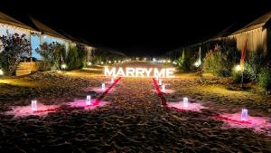 a sign that reads marry me lit up at night at The Jaisalmer Heritage Safari Camp in Sām