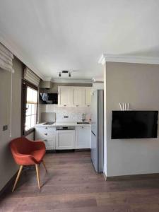 a kitchen with a red chair and a refrigerator at Gulhanim House in Marmaris