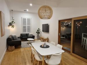 een woonkamer met een witte tafel en stoelen bij Live - Play - Stay - East Geelong in Geelong