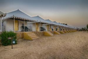 a row of tents in a row in the desert at The Jaisalmer Heritage Safari Camp in Sām
