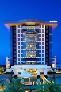 a building with a pool in front of it at Le Meridien Coimbatore in Coimbatore