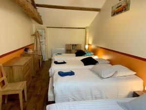 a bedroom with three beds and a wooden floor at Les Gites de la Richardiere in Saint-Révérend +55 photos