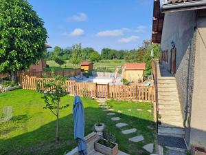 a backyard with a wooden fence and a yard at Maison d'hôtes des Bassins d'Oche in Saint-Paul-en-Chablais