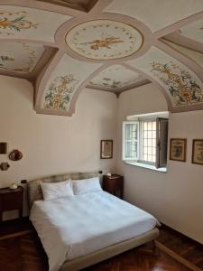 1 dormitorio con 1 cama y techo con reloj en SUITE VIA ROMA, en Cherasco