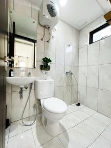 y baño con aseo, lavabo y ducha. en Larisa Homestay Syariah 2 en Padalarang