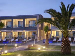 a building with palm trees in front of it at Sea Coast Resort Halkidiki in Yerakiní