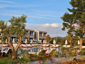 a resort with a pool with lounge chairs and umbrellas at Sea Coast Resort Halkidiki in Yerakiní
