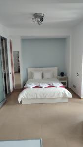 a white bedroom with a large bed in a room at ATCA House in Bucharest
