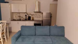 een woonkamer met een blauwe bank in een keuken bij Blue Ocean Aidipsos in Edipsos