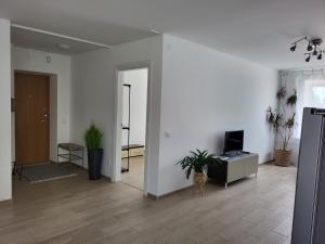 a living room with white walls and plants in it at JOREDA apartamentai in Biržai